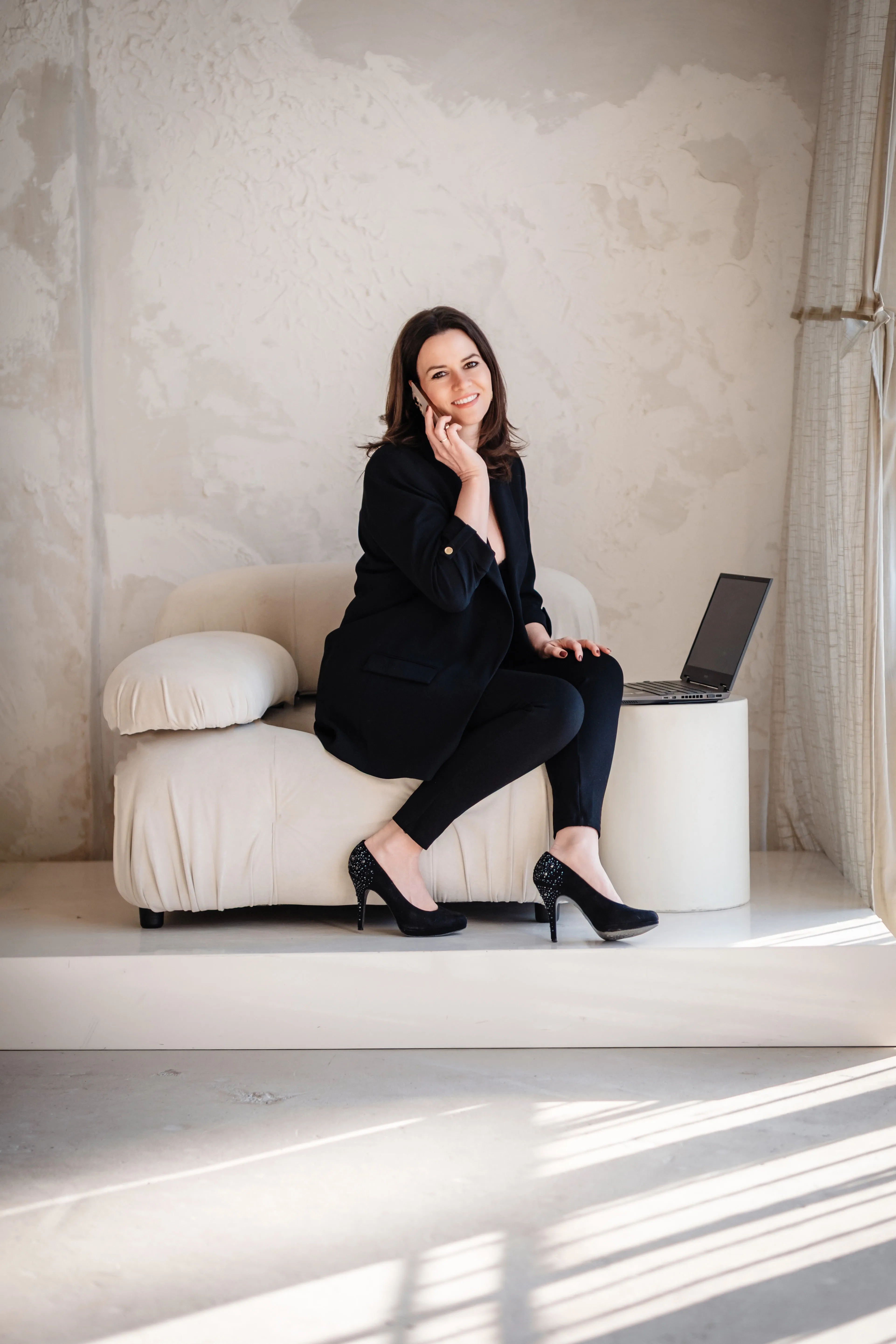 Sarah-Yasmin Hennessen sitzt lächelnd neben ihrem Laptop.